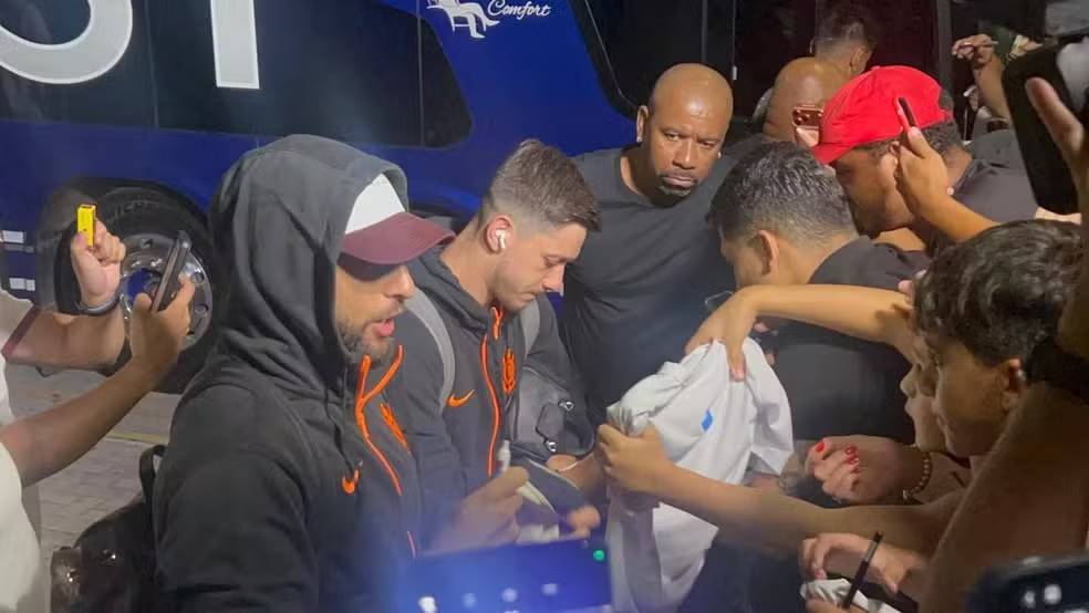 Yuri Alberto (de bon�) e Rodrigo Garro atendem os torcedores na porta de hotel onde est� o Corinthians � Foto: Gabriel Oliveira